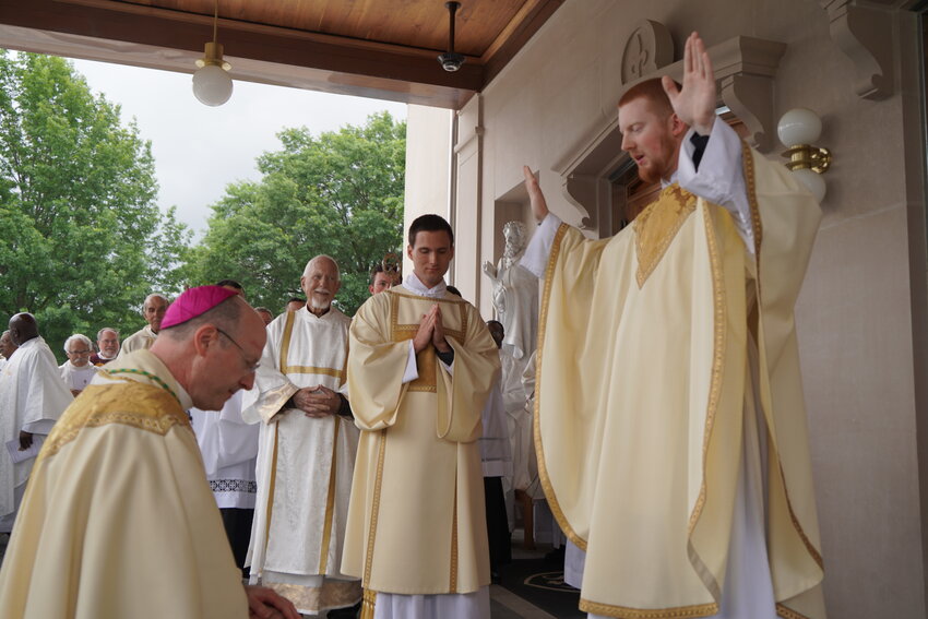 Deacon Turf Martin of Sedalia and newly ordained Rev. Mr. Gregory Clever watch newly ordained Father Christopher Hoffmann bestow his first priestly blessing on Bishop W. Shawn McKnight outside the Cathedral of St. Joseph June 1 after the priestly and diaconal ordination.