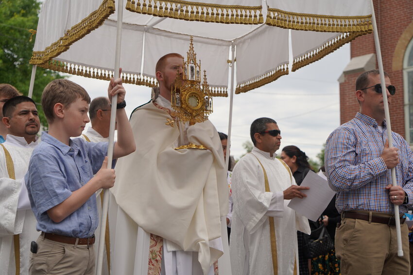 Father Christopher Hoffmann carries the Most Blessed Sacrament down the main thoroughfare through downtown Sedalia during a Eucharistic Procession on June 2, the Solemnity of the Most Holy Body and Blood of Christ.