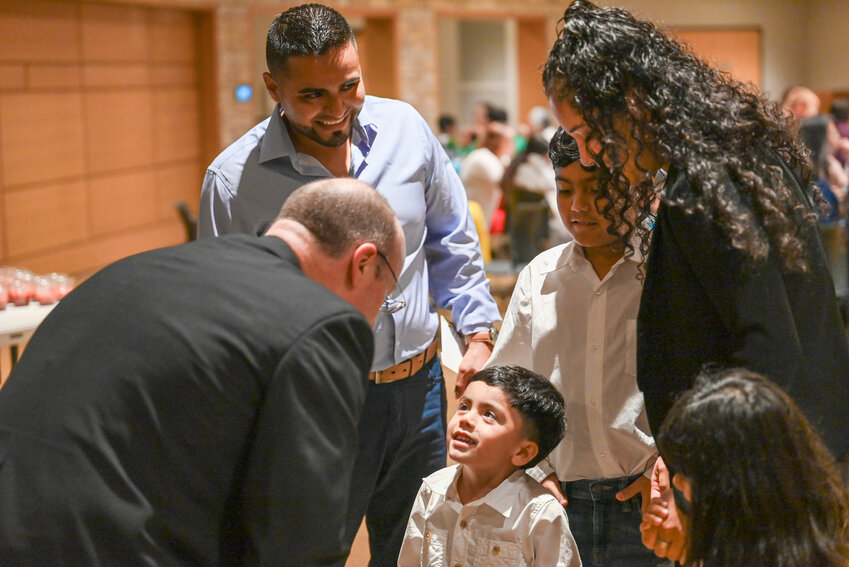 Bishop W. Shawn McKnight greets a child and his family at the reception luncheon after the diocesan Hispanic Heritage Mass on June 23 in the Cathedral of St. Joseph.