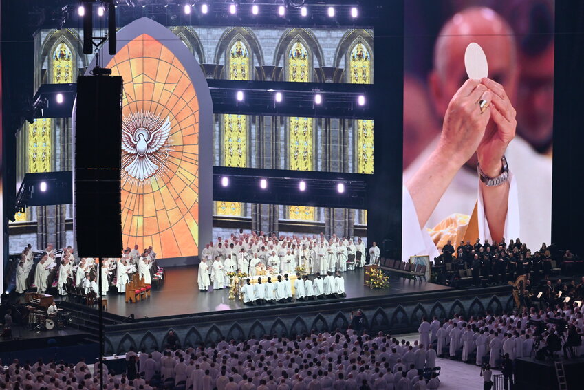 On massive video screens, Cardinal Luis Antonio Tagle, Pope Francis&rsquo;s special envoy to the 10th National Eucharistic Congress, can be seen elevating the Most Blessed Sacrament during the sending-forth Mass on Sunday, July 21, in the Lucas Oil Stadium in Indianapolis. More than 60,000 bishops, priests, deacons, religious and laypeople attended the Mass.