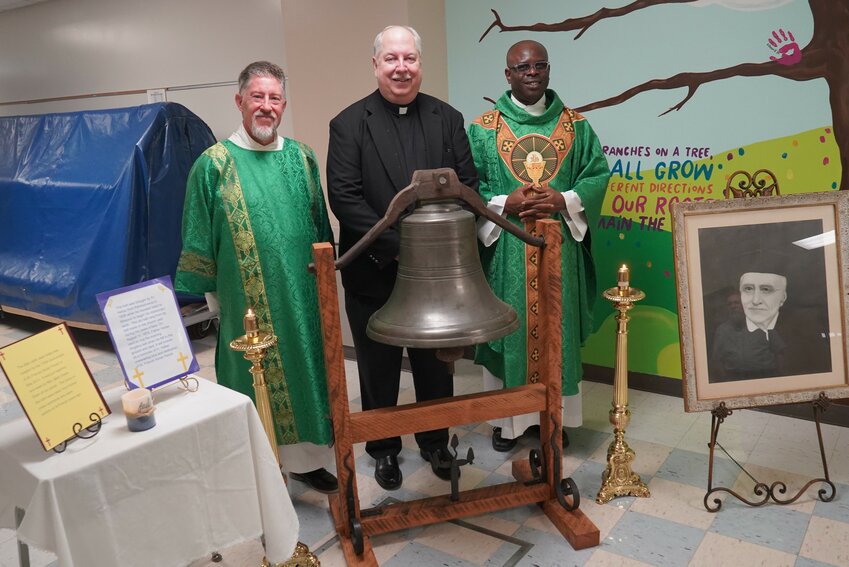 Deacon Michael Berendzen, who assists the pastor of St. Francis Xavier Parish in Taos; Monsignor Robert A. Kurwicki, vicar general of the Jefferson City diocese and pastor of St. Peter Parish in Jefferson City; and Father Kelechi Uzuegbu, pastor of St. Francis Xavier Parish in Taos, gather around the church bell from the old St. Francis Xavier Church built by Jesuit Father Ferdinand Helias (1796-1874), known by many as the &ldquo;Apostle of Central Missouri,&rdquo; on Aug. 11, the 150th anniversary of the priest&rsquo;s death. Msgr. Kurwicki presided at Mass and preached the homily in observance of the anniversary.
