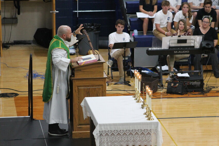 Father Paul Clark, chaplain, preaches the homily at Helias Catholic High School&rsquo;s Homecoming Mass in the Rackers Fieldhouse in Jefferson City.