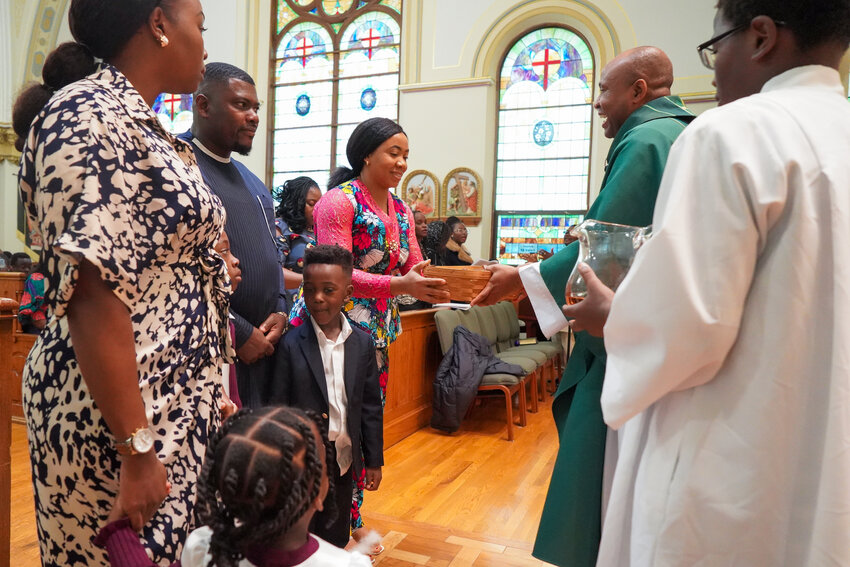 People from the congregation present the bread, wine and offertory collection to Father Roberto Ike during the African Thanksgiving Mass celebrated on Nov. 17 in Sacred Heart Church in Columbia.