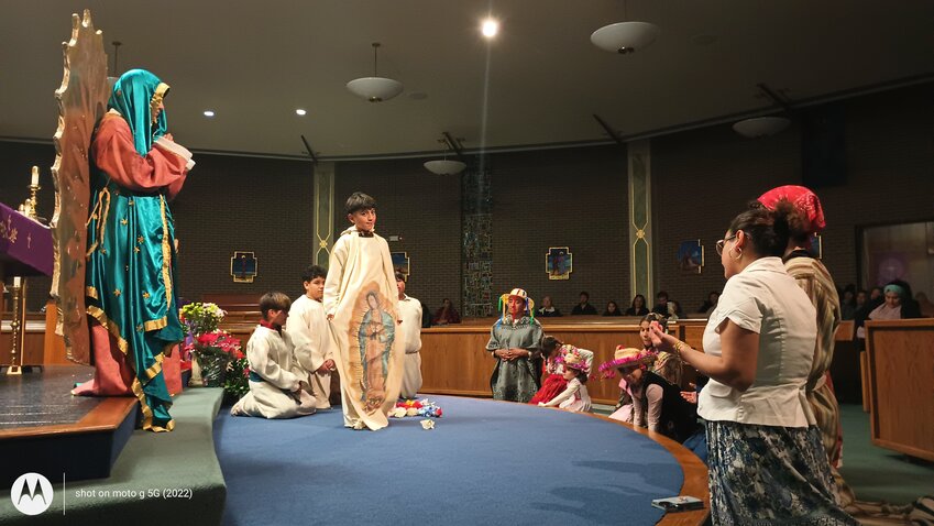 Members of St. Peter Parish in Marshall act out the story of Our Lady of Guadalupe and St. Juan Diego during a holy hour on Dec. 13 in St. Peter Church.
