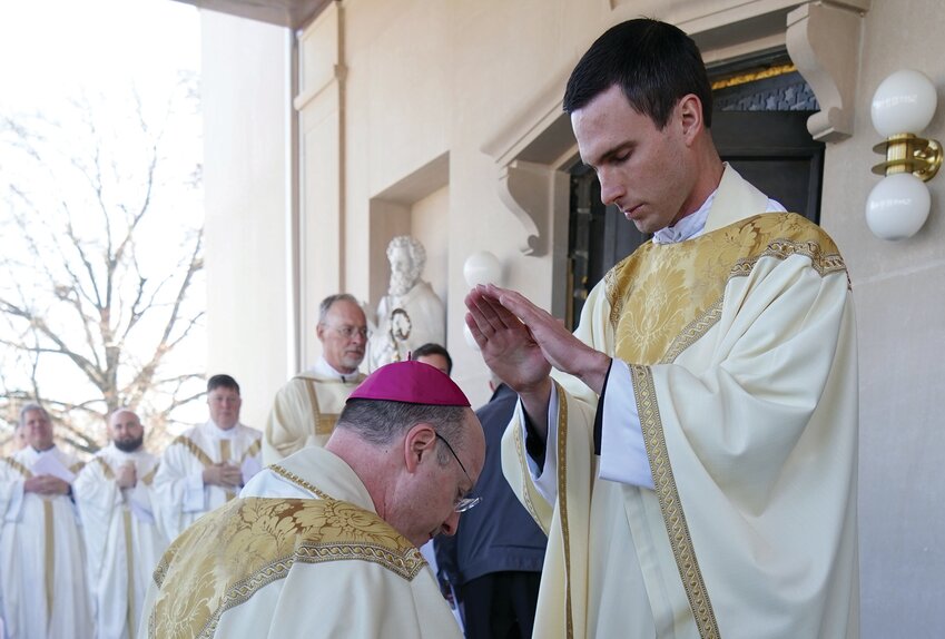 Newly ordained Father Gregory Clever gives his first priestly blessing to Bishop W. Shawn McKnight outside the Cathedral of St. Joseph Dec. 7, following Fr. Clever&rsquo;s ordination to the Priesthood.