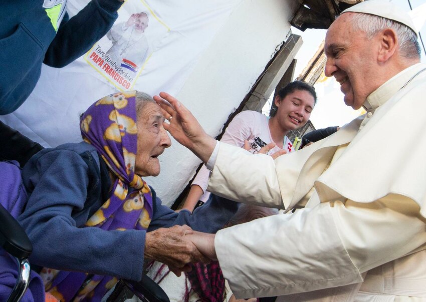 Pope Francis greets an elderly woman as he meets with people of the Banado Norte neighborhood in the Chapel of St. John the Baptist in Asuncion, Paraguay, July 12, 2015.