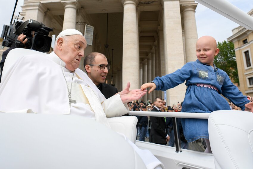 Pope Francis greets a child from the popemobile after giving his Easter blessing to thousands of people in St. Peter's Square at the Vatican April 20, 2025. Pope Francis, formerly Argentine Cardinal Jorge Mario Bergoglio, died April 21 at age 88.