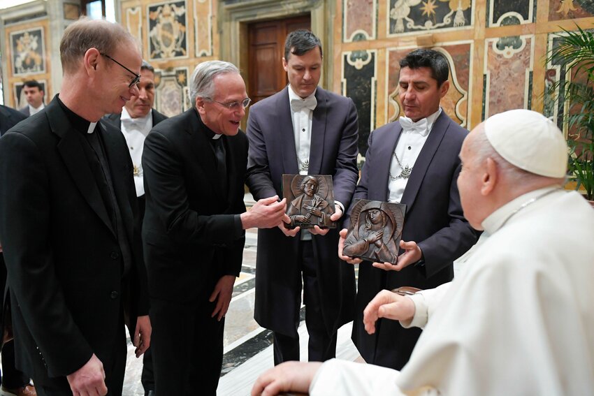 Pope Francis receives gifts from Holy Cross Father John I. Jenkins, who at that time was president of the University of Notre Dame, center, and Holy Cross Father Robert A. Dowd, who was president-elect, left, during a meeting with the university's board of trustees at the Vatican Feb. 1, 2024.