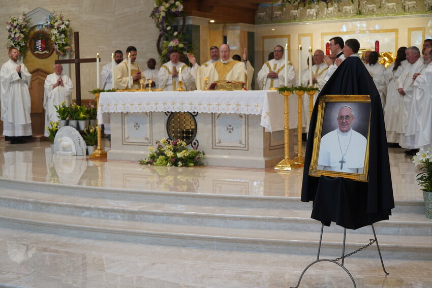 A framed image of Pope Francis, draped in black, is displayed in the sanctuary of the Cathedral of St. Joseph in Jefferson City, as Archbishop Shawn McKnight and more than 40 priests of the diocese offer a Memorial Mass for the pope, who died on April 21 at age 88.