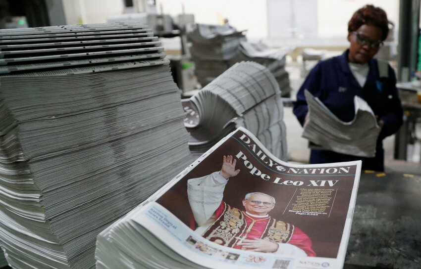 A worker arranges printed newspapers for circulation with a picture of the newly elected Pope Leo XIV, Cardinal Robert Prevost of the United States, at the Nation Media Group printing press on the outskirts of Nairobi, Kenya, May 8, 2025.