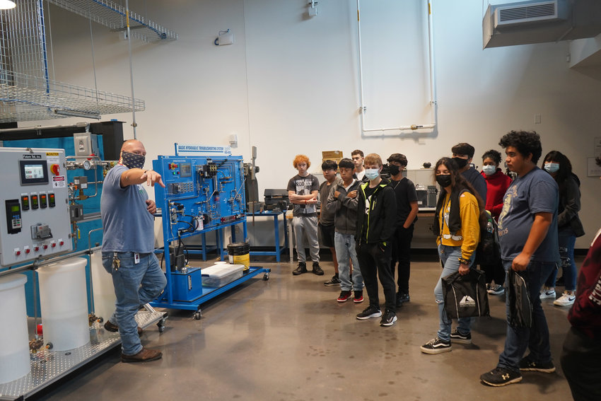 Scottie Spears (left), director of Industrial Systems Technology, gives a group of students a tour of his lab during Industrial Career Day at GNTC.