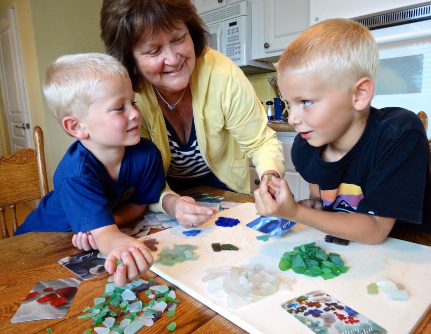 A family sorts and identifies sea glass collected from the coast.