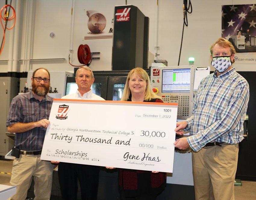 The Gene Haas Foundation presents a grant of $30,000 to GNTC on Wednesday, Dec. 7. (From left) Bart Jenkins, director of Precision Machining and Manufacturing at GNTC; David Aycock, Haas sales engineer; Dr. Heidi Popham, GNTC president; and Philip Shirley, Precision Machining and Manufacturing instructor, stand in front of a Haas VF2 Computer Numerical Control milling machine at the Whitfield Murray Campus.