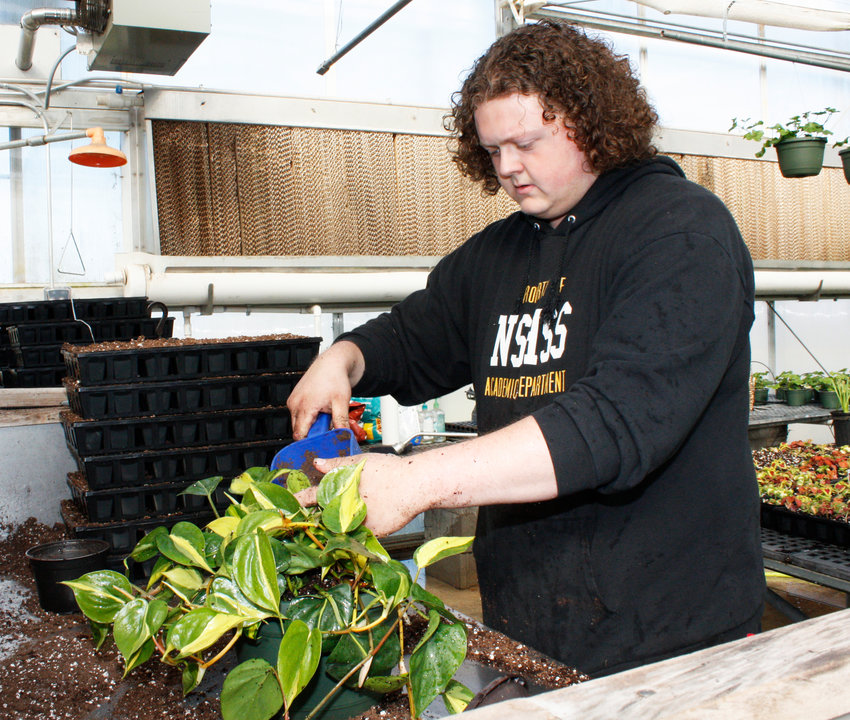 GNTC Horticulture student Grant Payne repots a plant to get ready for the plant sale.