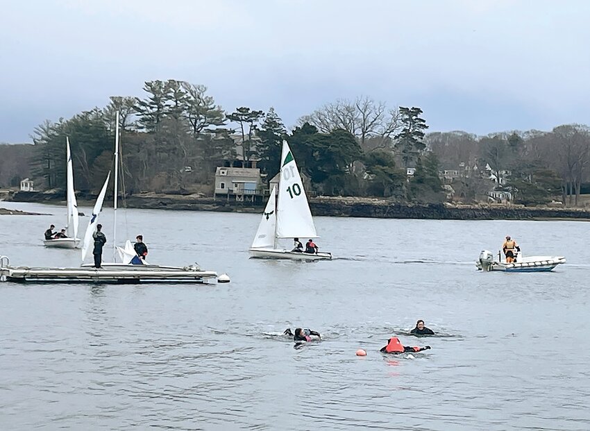 Coed sailing team members practice cold-weather drills.