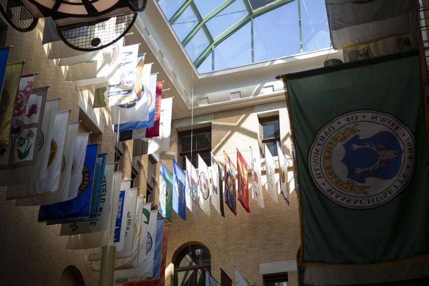 Beams of sunlight illuminate city and town flags in the Legislature's Great Hall on March 19, 2025.