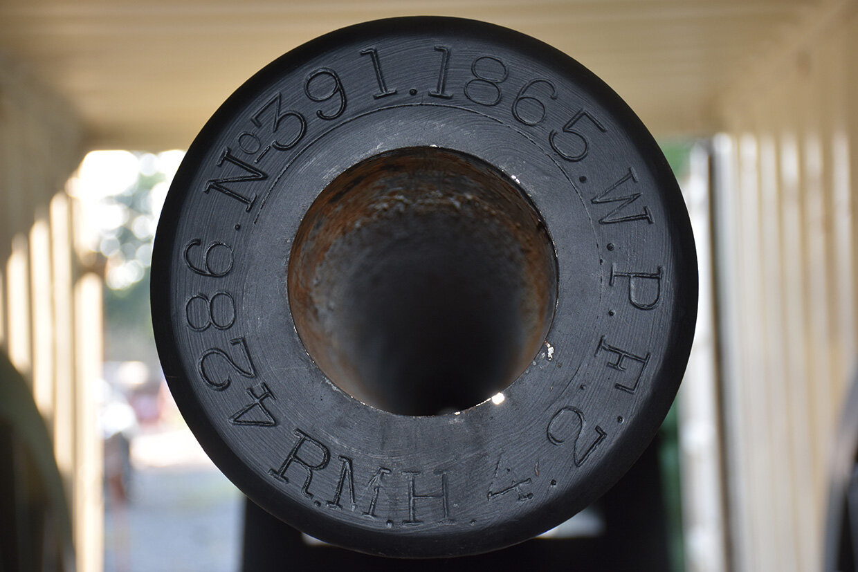 Looking down the barrel of The Parrott. The original inscriptions now visible include the year she was designed by Robert P. Parrott (1865), her weight (4286 lbs.), the measurement of her borehole (4.2), the official U.S. stamp, the initials of the man in charge (RMH) of West Point Foundry (WPF) where she was forged, and her barrel number (391).