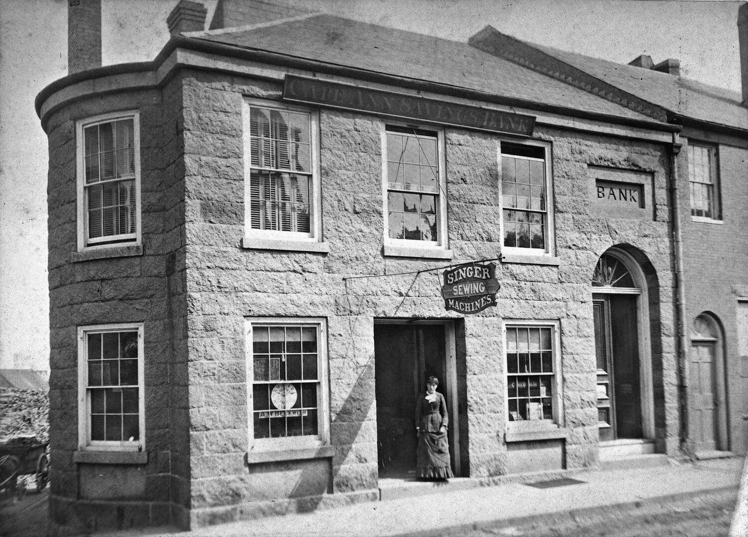 Photo by Edward Corliss &amp; J. F. Ryan, 1882. 51-53 Main St. Cape Ann Savings Bank. 53 -Singer Manuf. Co, sewing machines, C.H. Fennimore agent.