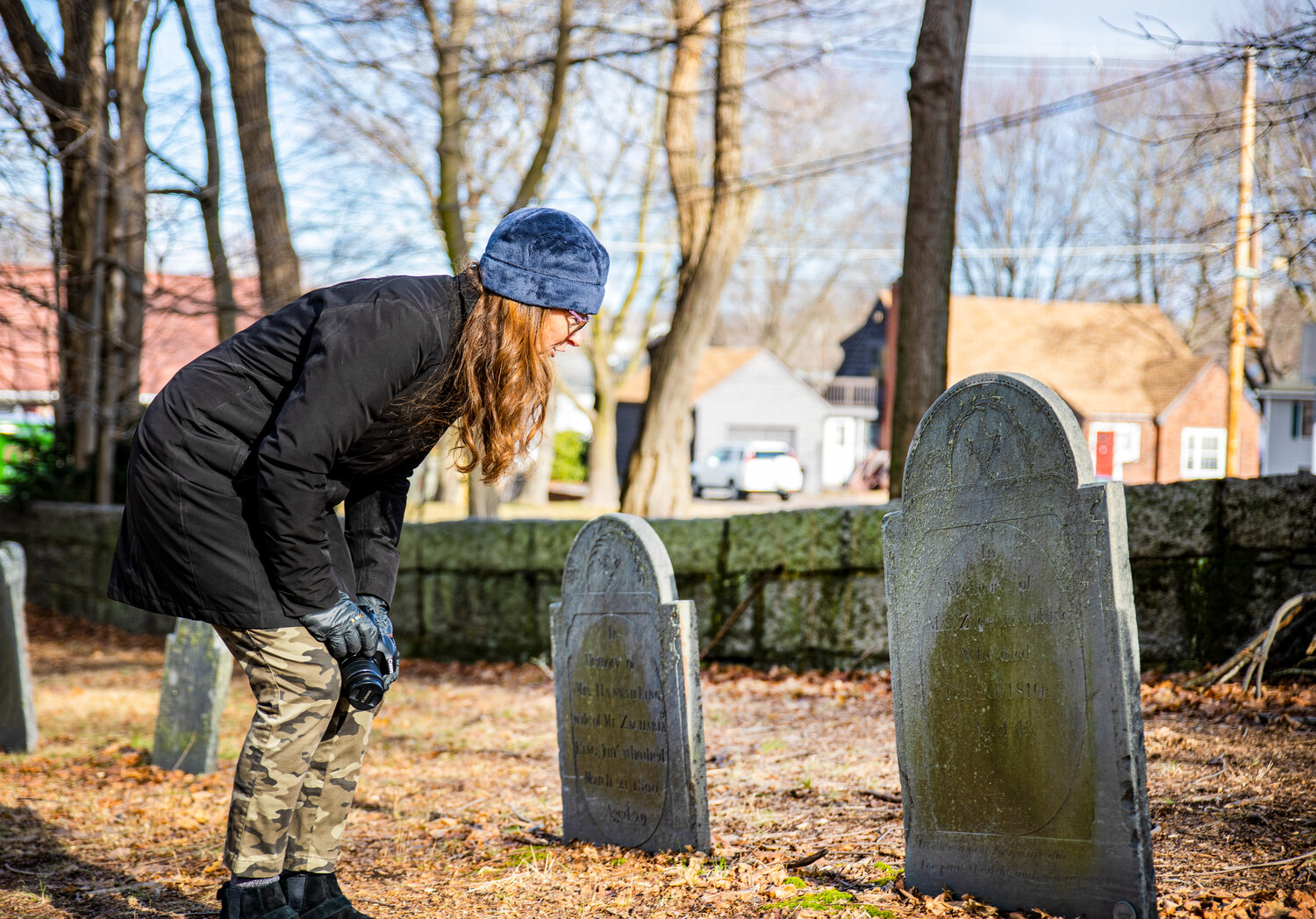 Christy King faces the tombstone of Zachariah King Jr., whose portrait is still in her family, in the historic King Cemetery named for her family, located in Peabody formerly part of Salem and Beverly.