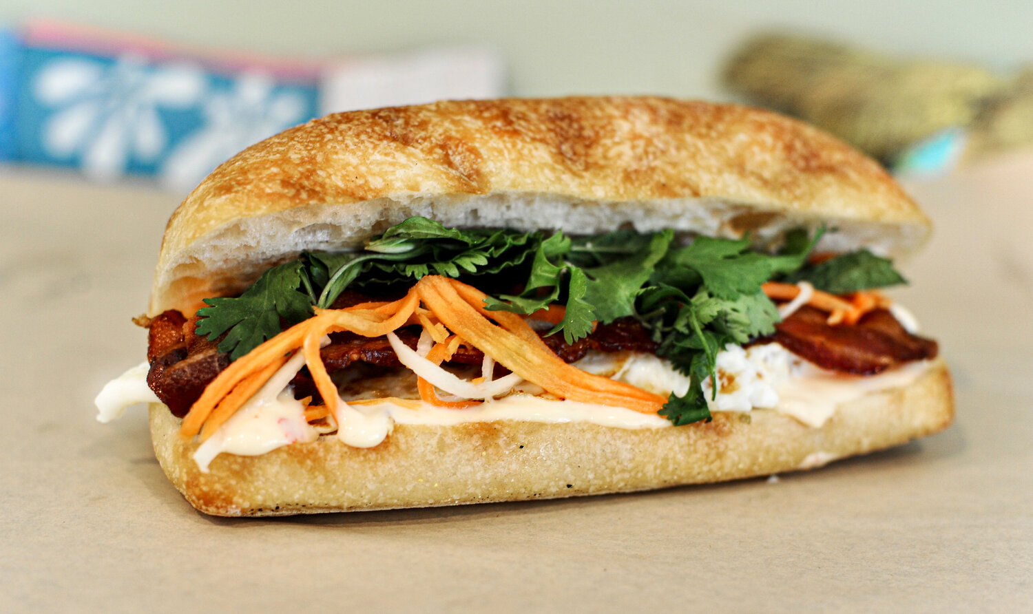 Breakfast Bahn Mi - A Vietnamese inspired breakfast sandwich with egg, bacon, pickled veg, Thai aioli, cilantro, and mint on a French baguette.
