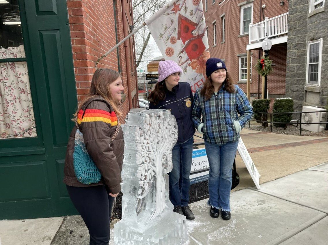 Teens pose in front of an ice sculpture on Main Street during Gloucester’s So Salty 2023