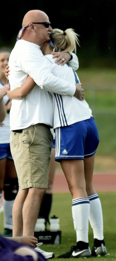 In this April 12, 2018, file photo, Cass girls soccer coach Phil Phillips hugs Logan Vermaas after she set the school record for goals in a single season against Darlington at Doug Cochran Stadium. Phillips died Thursday at 65.