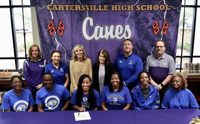 Cartersville High senior Makiya Tart signed to cheer at Shorter University in Rome. On hand for the signing were, from left, front row: Tamika Tart, stepmother; Michael Tart, father; Branden Stanberry, mother; Micah Tart, brother; Pamela Ellis, grandmother; back row, Shelley Tierce, CHS principal; Indiana Kimbrough, Shorter head competition coach; Cissy Adams; Rondi Craig; Jason Stockton, Shorter head cheer coach; and Darrell Demastus, CHS athletic director.