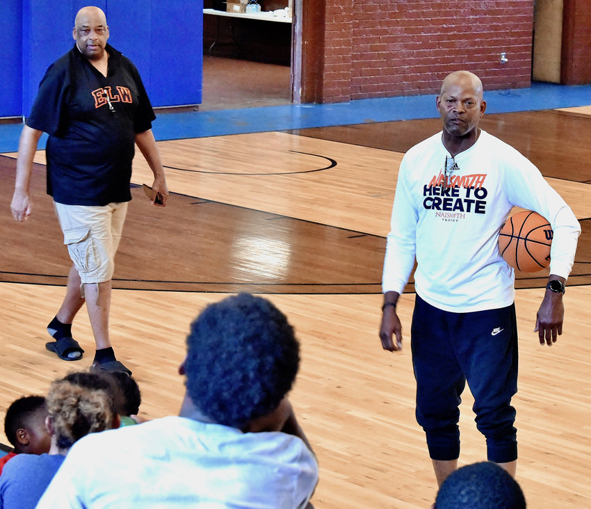 Former NBA standout and Marietta High graduate Dale Ellis, right, talks to attendees of the annual basketball camp hosted by Cass High product Eddie Lee Wilkins, left, June 16 at the J.H. Morgan gym on Aubrey Street.