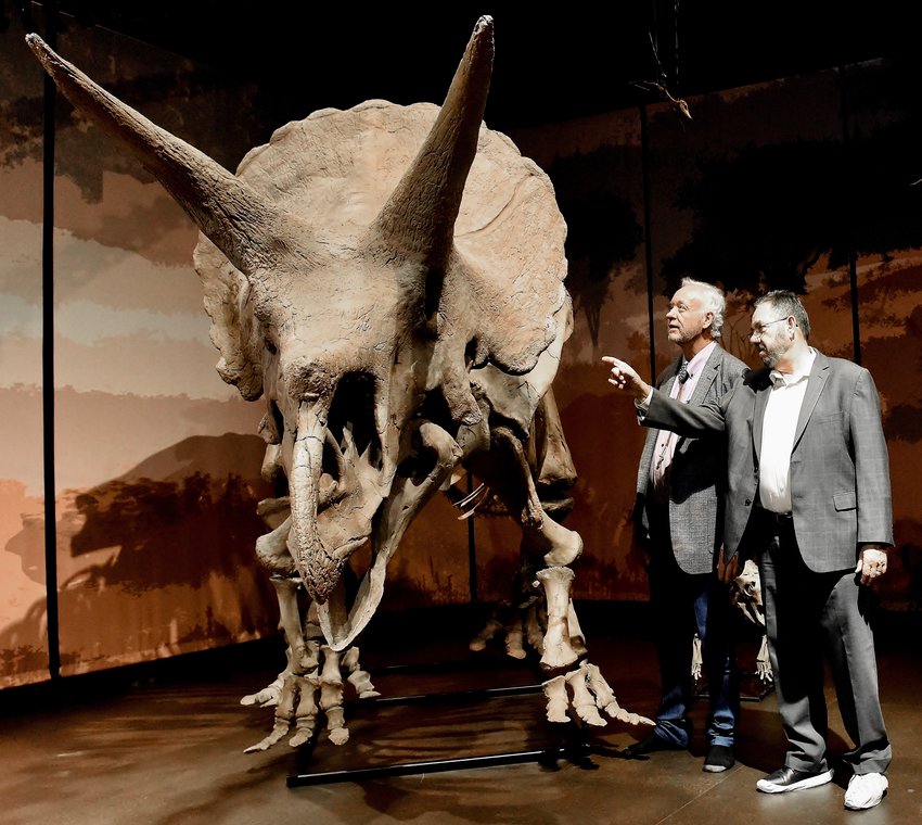 Tellus Science Museum Executive Director Jose Sanatamaria, right, and longtime Tellus supporter Michael Mayo Macke examine Lane &mdash; a triceratops, which now features its entire skeleton with funds provided by Macke.