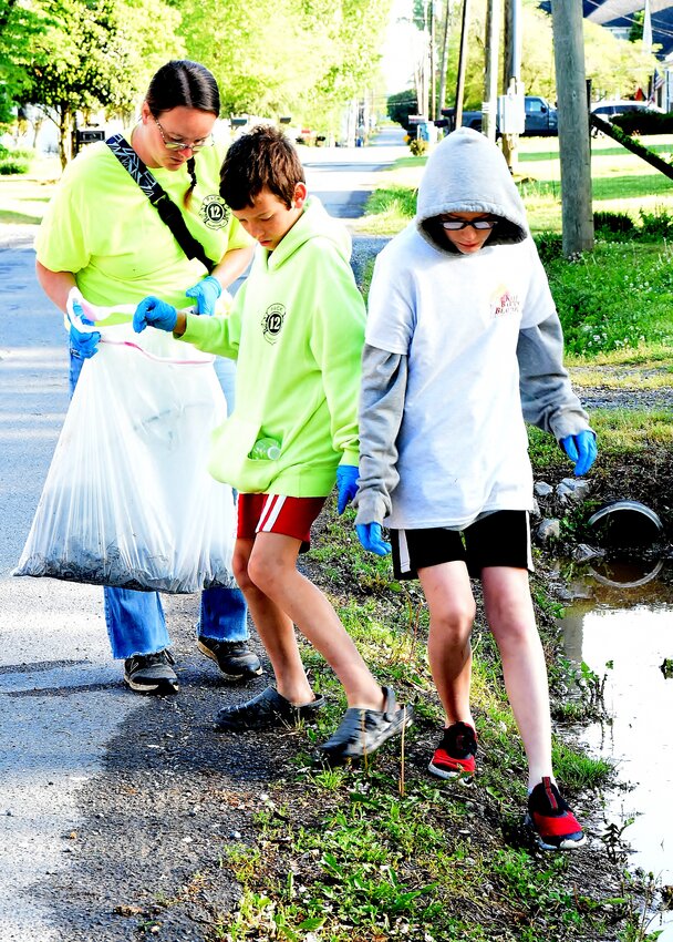 Christina Anderson picks up litter in Adairsville with her 10-year-old son, Kyler, and 14-year-old nephew, Jayden McDougle.