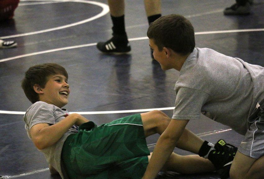 Brock Templar, left, cracks a smile after Hudson Loges took him down Wednesday during the first day of the Blair Wrestling Camp.