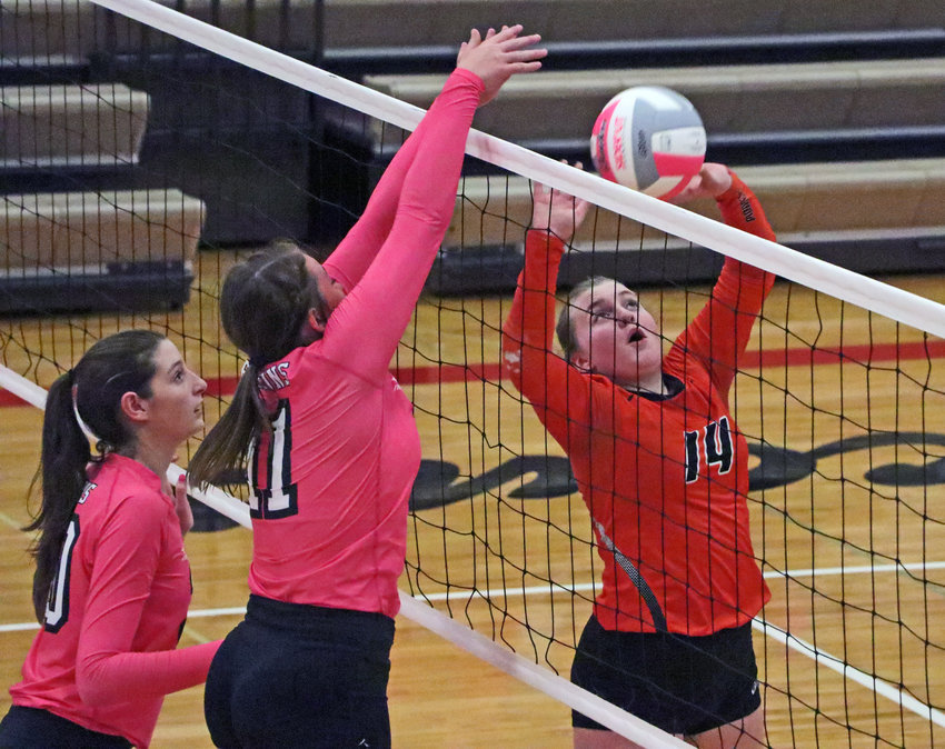 Fort Calhoun senior Rianna Wells, right, sets the ball as the Falcons' Nora Wurtz, left, and Keira Murdock play defense Tuesday at Douglas County West.