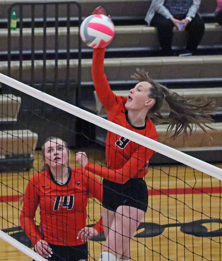 Fort Calhoun's Grace Genoways spikes the ball as Rianna Wells watches Tuesday at Douglas County West.