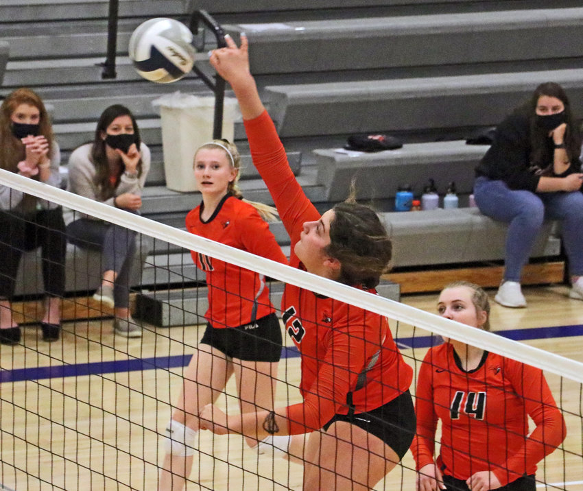 Fort Calhoun senior Alivia Cullen, middle, spikes the ball as Olivia Quinlan, left, and Rianna Wells look on Monday at Wahoo High School.