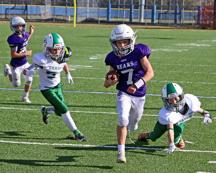 BYFA fourth-grade quarterback Barrett Brown races away from Gretna Jr. Dragons on Saturday at Millard North High School.