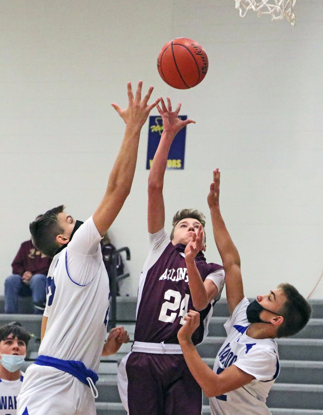 Arlington eighth-grader Dallin Franzluebbers, middle, puts up a shot between a pair of Warriors on Saturday at Wahoo High School.