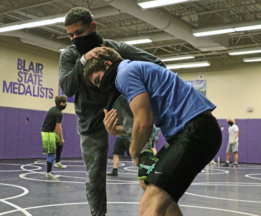 Dylan Berg latches onto Yoan Camejo's leg Tuesday during practice at Blair High School.