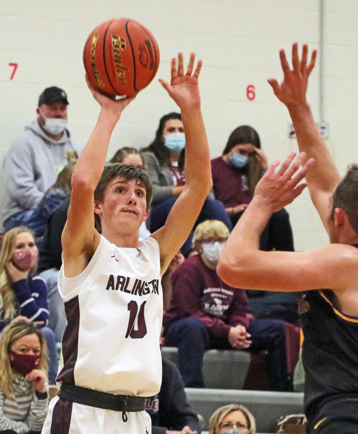 The Eagles' Colby Grefe, left, fires and makes a transition 3 on Friday at Arlington High School.