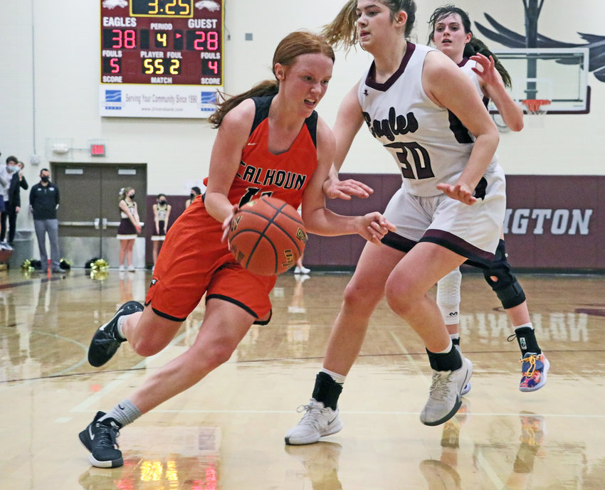 Fort Calhoun senior Abbie Anderson, left, drives the ball by Eagles Kate Miller, middle, and Keelianne Green on Friday at Arlington High School.