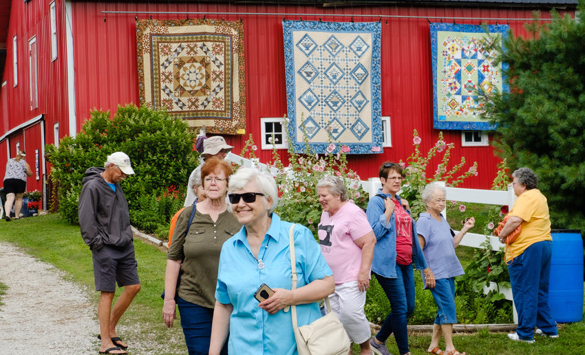 Visitors stroll along pathways admiring beautifully groomed beds of flowers as well as quilt displays Saturday at Doug and Teri Wolfe's farm.