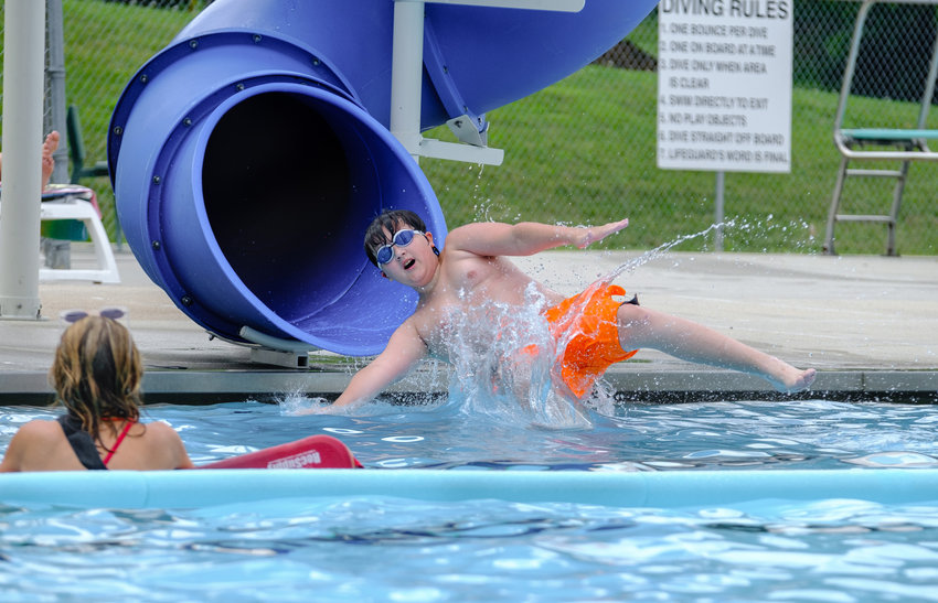 Zathan Prime shoots out of the spiral tube and splashes into the water under the watchful eye of lifeguard Angel Nelsen at the Blair Municipal Pool on Sunday afternoon.  .