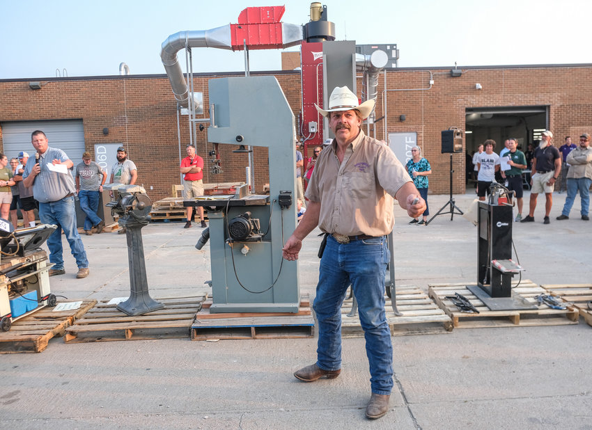 Gary Lambrecht takes bids for old industrial arts equipment that was sold following an open house event for the newly renovated industrial arts center at Blair High School. Funds from the auction were to go back to the program.