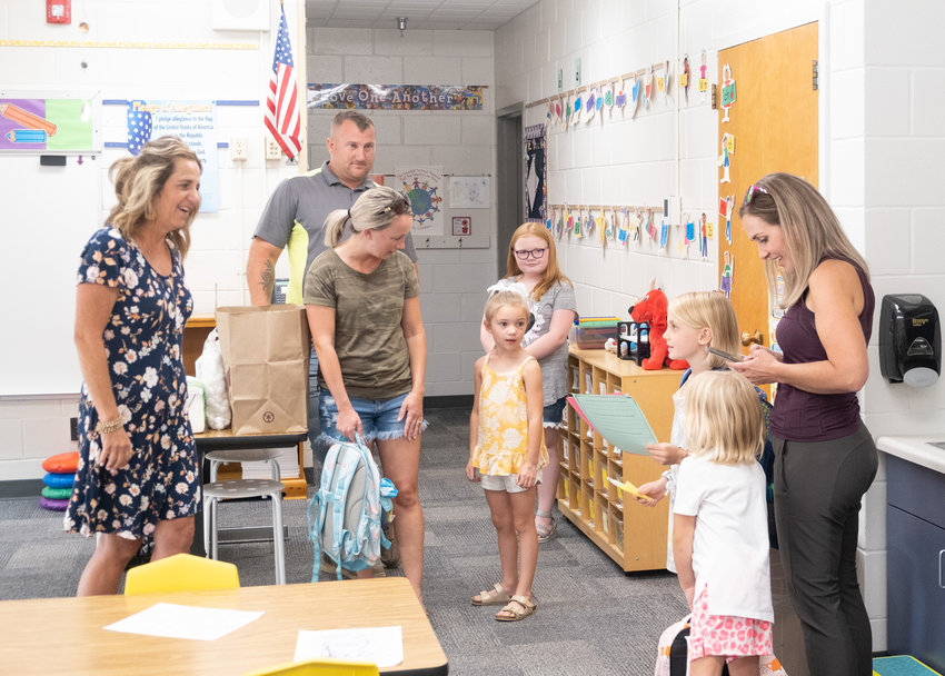 South kindergarten teacher Sheryl Krueger greets students and family members during back-to-school night on Monday.