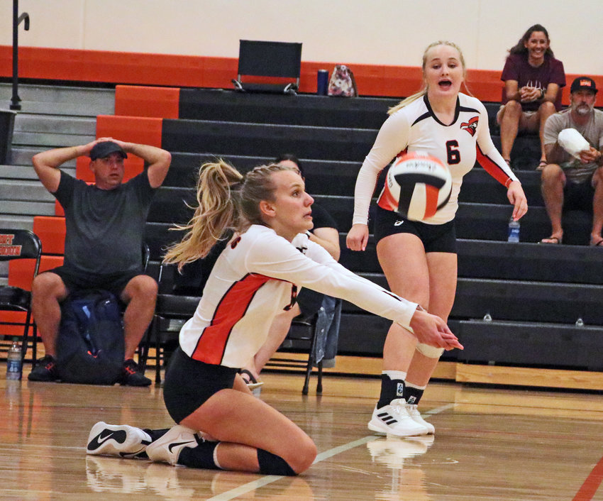 The Pioneers' Bailee Spencer slides in to receive a serve in front of teammate Raegen Wells on Thursday at Fort Calhoun High School.