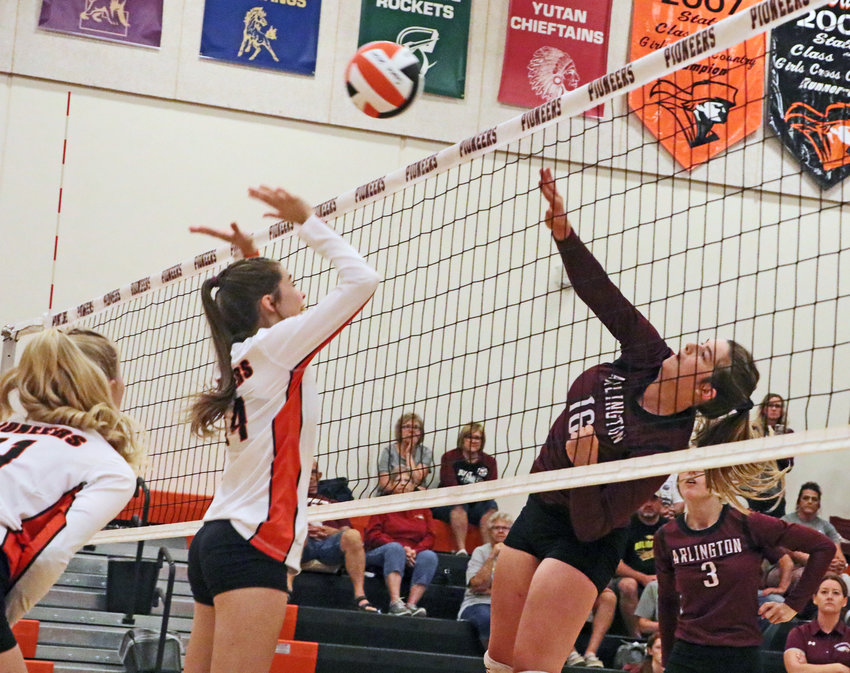 Arlington senior Kate Miller spikes the ball over the hands of the Pioneers' Ellie Collins on Thursday at Fort Calhoun High School.