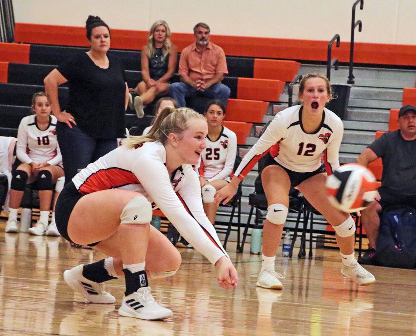 The Pioneers' Raegen Wells gets low to the floor for the ball as teammate Abbey Lienemann communicates the play Thursday at Fort Calhoun High School.