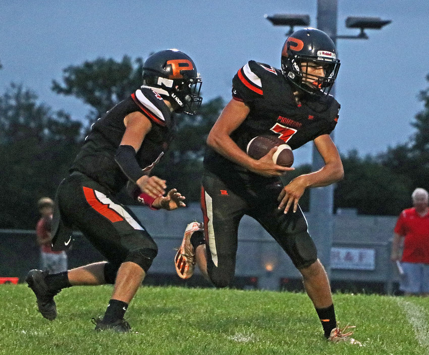 The Pioneers' Ty Hallberg, left, hands the ball off to Austin Welchert on Sept. 3 at Fort Calhoun High School.