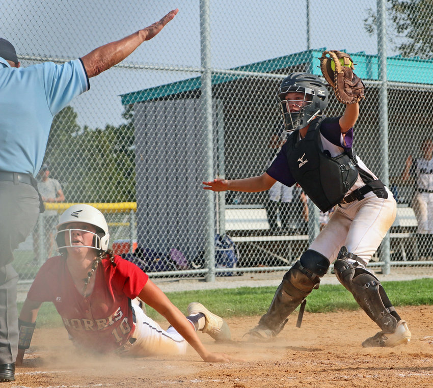 Blair catcher Nessa McMillen shows the umpire the ball in her glove, but he calls the Norris base runner safe at the plate Saturday during the Eastern Midlands Conference Tournament at the Youth Sports Complex. The Titans won the third-place game 4-3.
