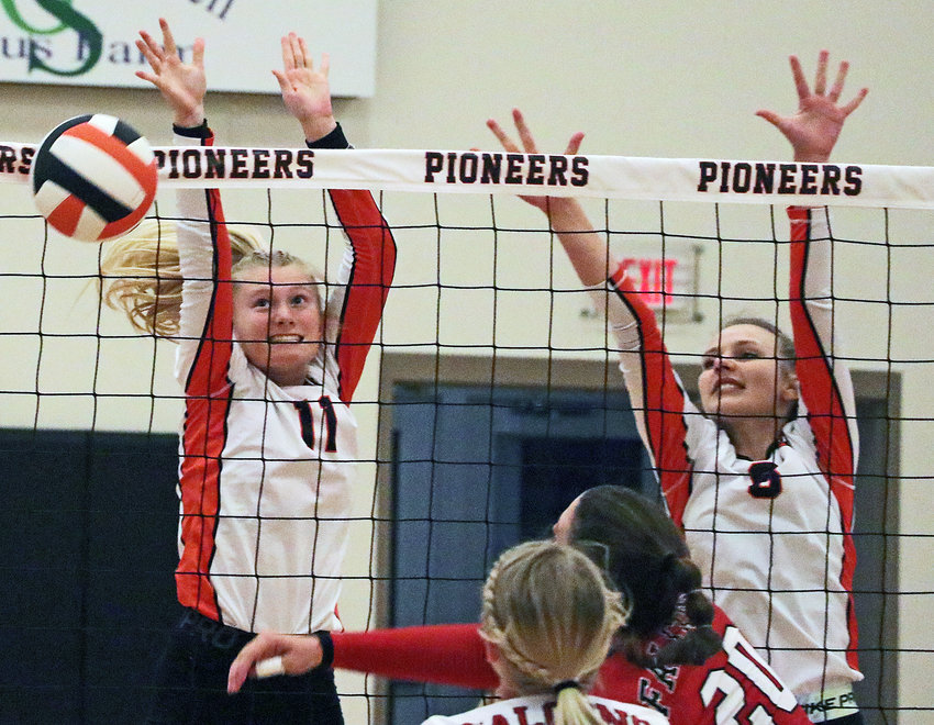 The Pioneers' Olivia Quinlan, left, and Bailee Spencer are in position to block a Douglas County West attack, but the Falcons hit the ball into the net Monday at Fort Calhoun High School.
