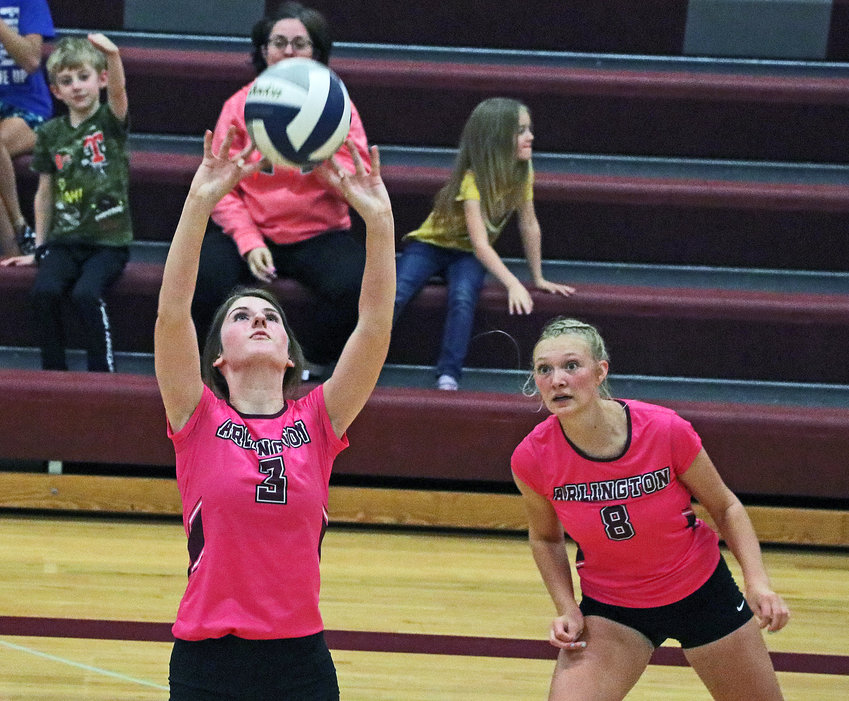 Eagles senior Janessa Wakefield, left, sets the ball as Austyn Flesner moves into position Tuesday at Arlington High School.